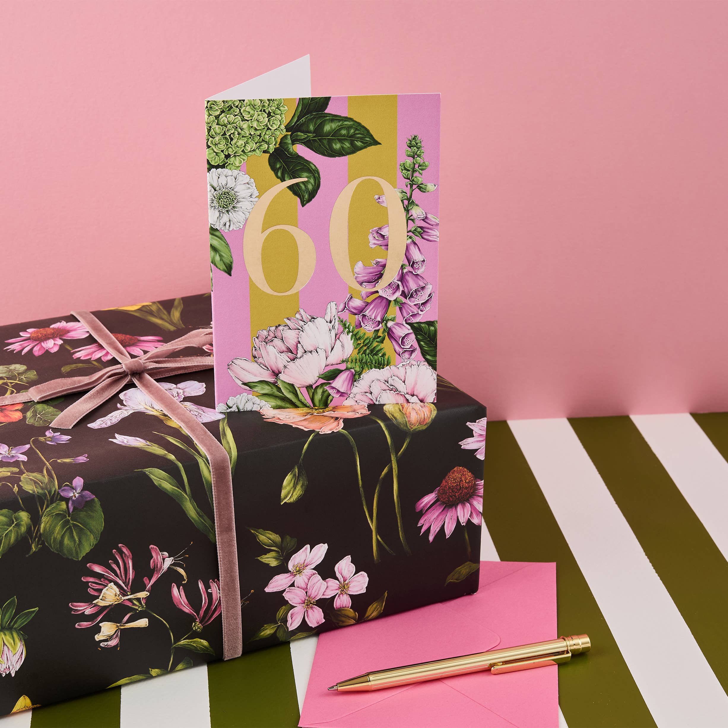 Floral gift box with a matching card on a pink background.