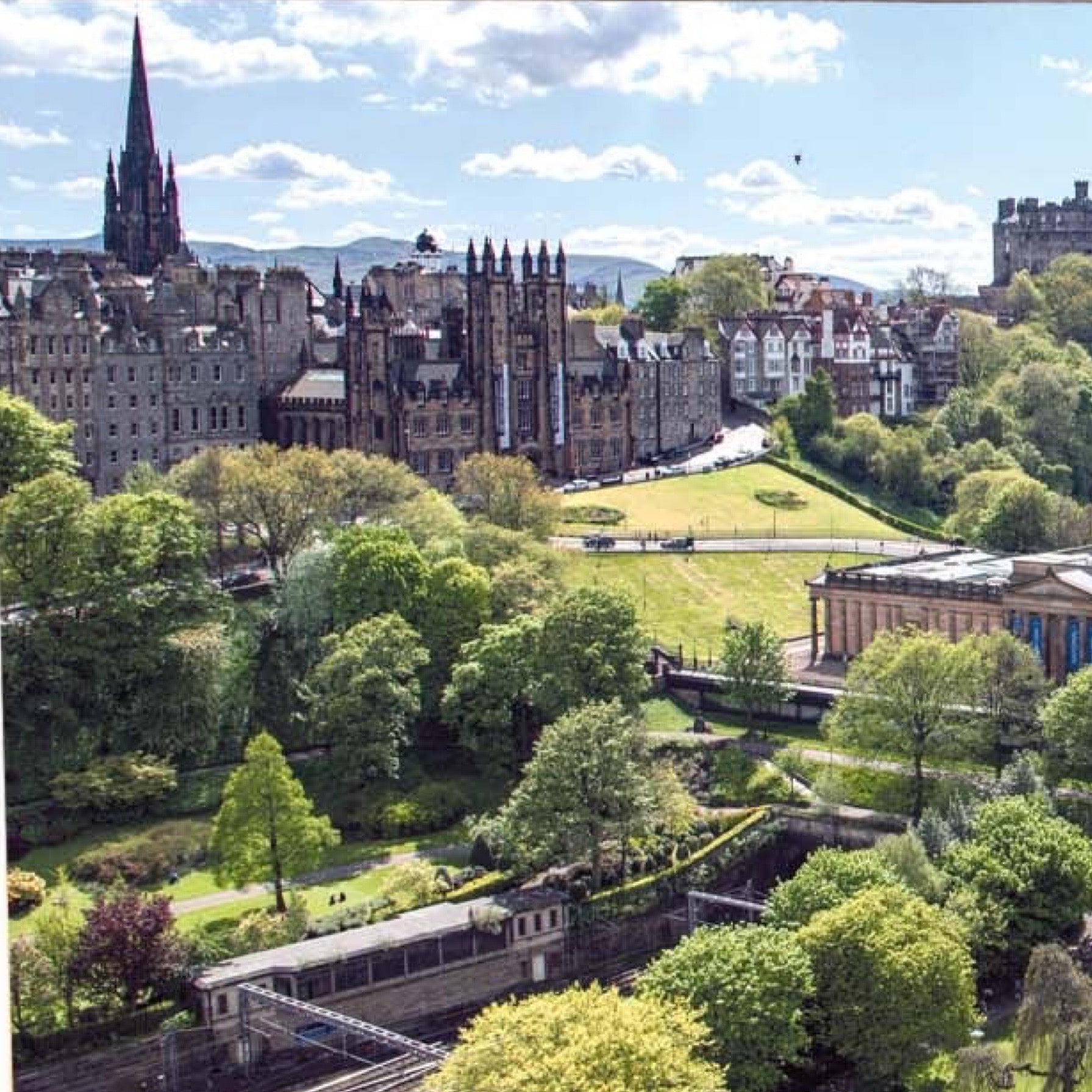 An image taken from the Scott Monument of Princes Street Gardens and Edinburgh Castle on a card.