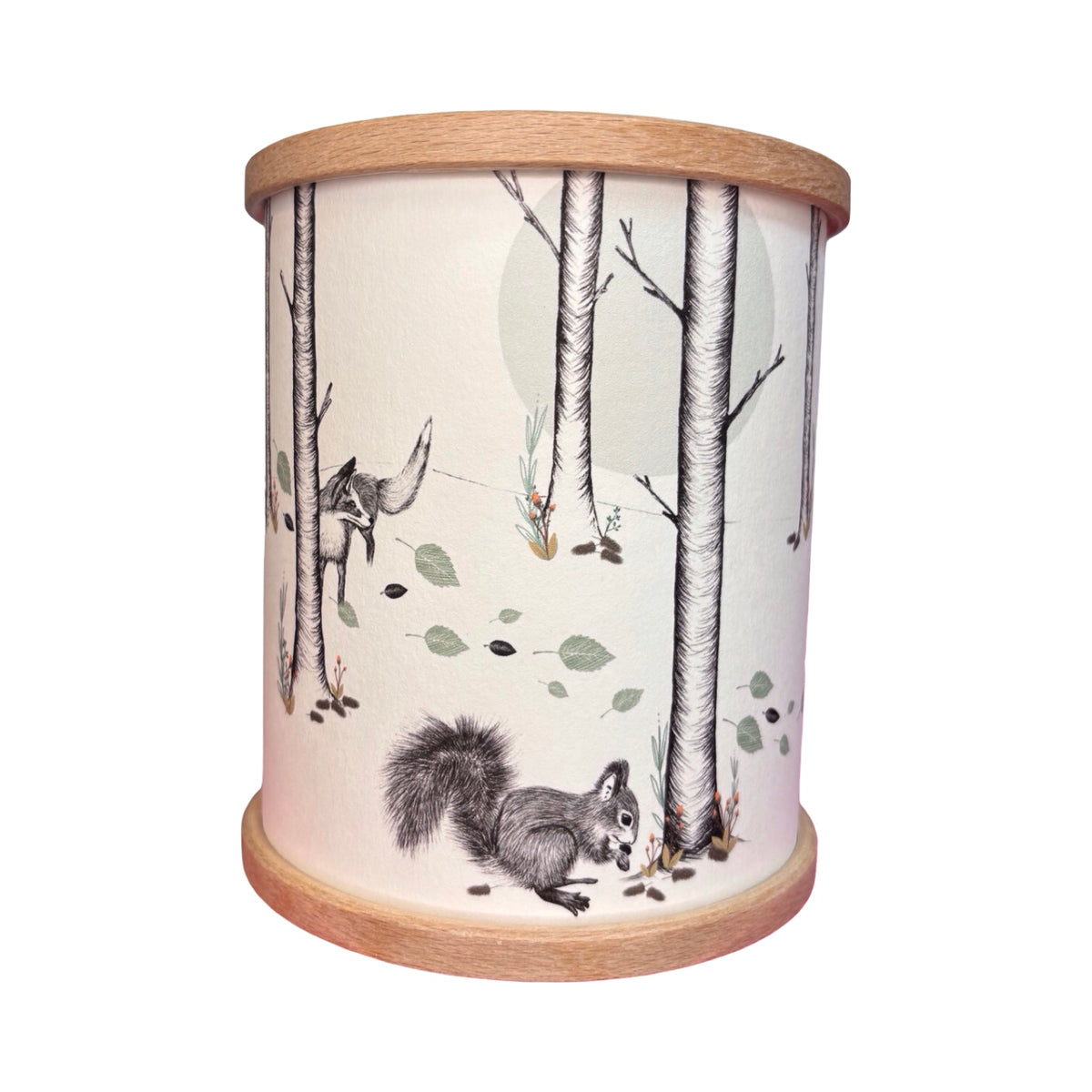 A cylindrical candle holder with a light wood rim and base, featuring a woodland illustration of a squirrel and fox among birch trees.