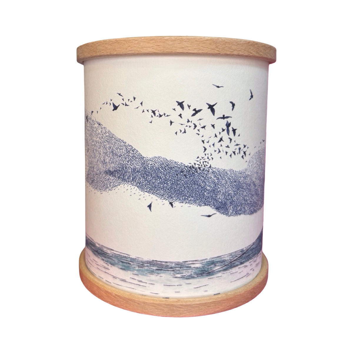 A cylindrical candle holder with a light wood rim and base, featuring an illustration of a murmuration of birds.
