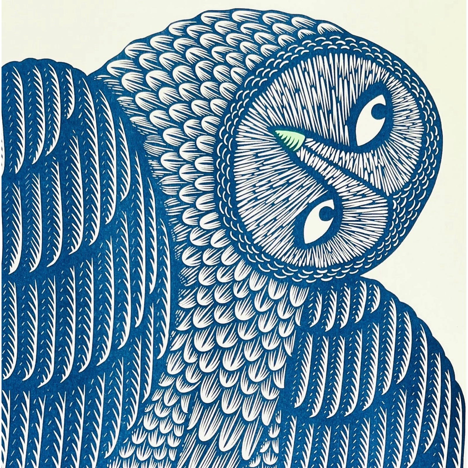 The head of a navy owl with a green beak turned to the left.