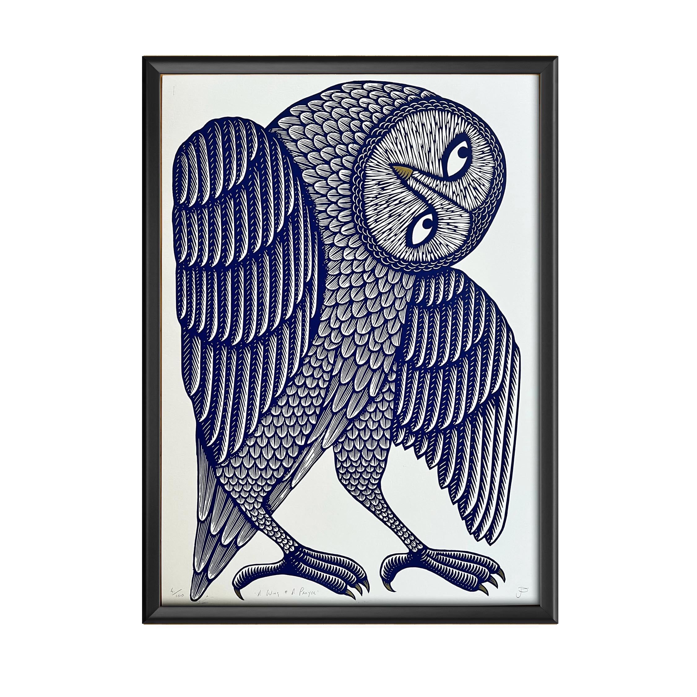 A print of a navy owl with its head turned to the left in a black frame.