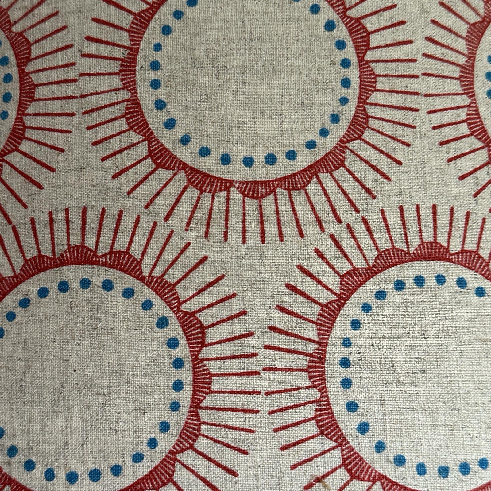Cream fabric with red abstract flowers and blue spots.