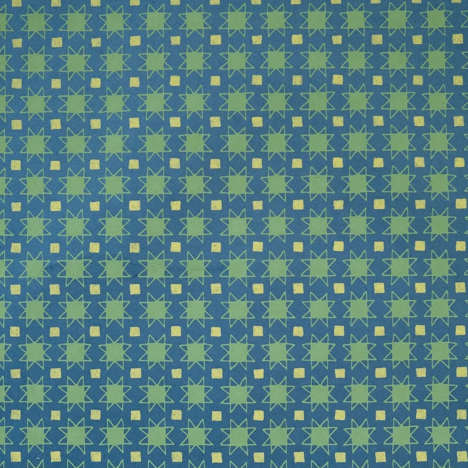 Wrapping paper with green stars and yellow squares against a blue background.