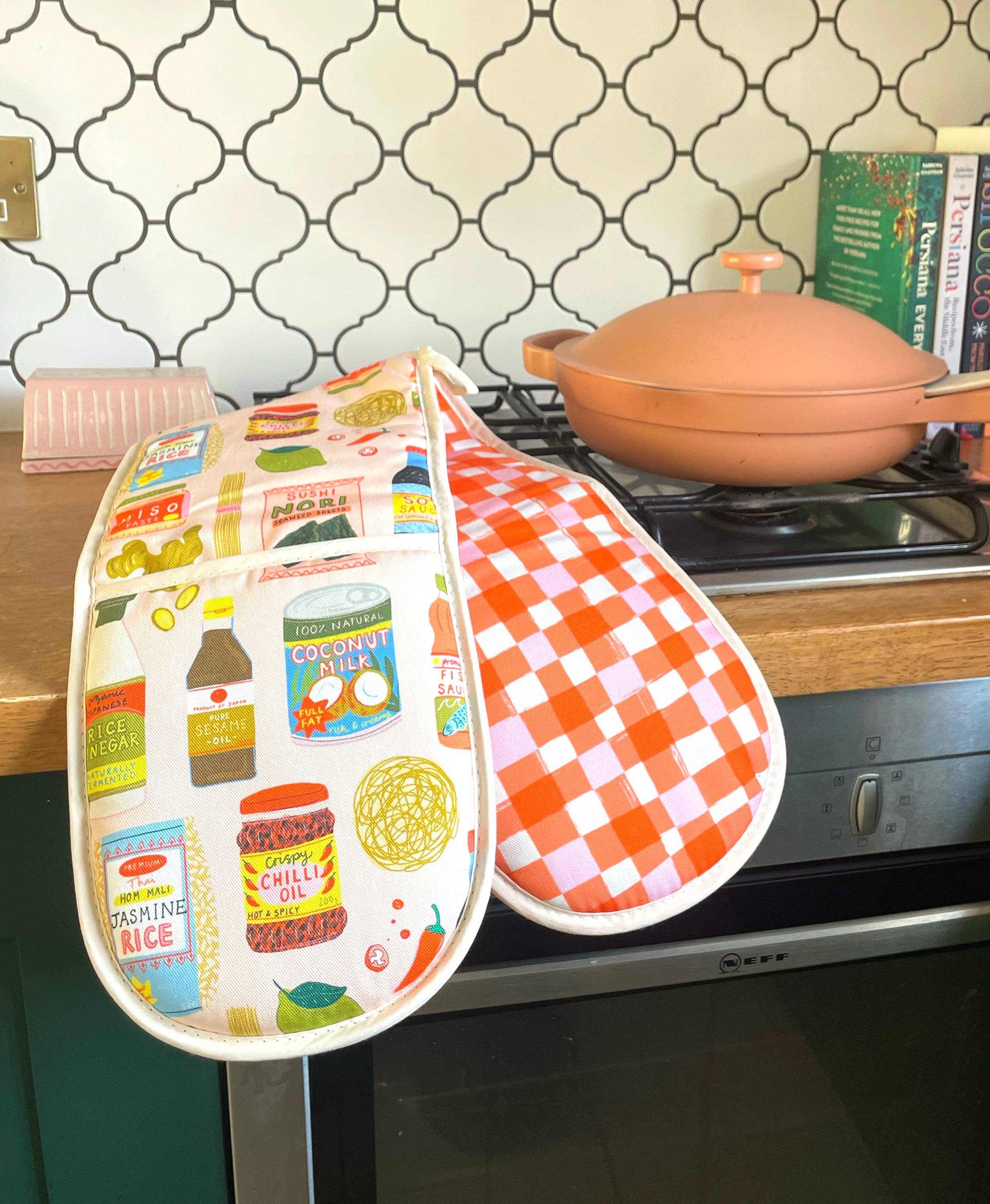 Colorful oven mitt with food-themed design on a kitchen counter.