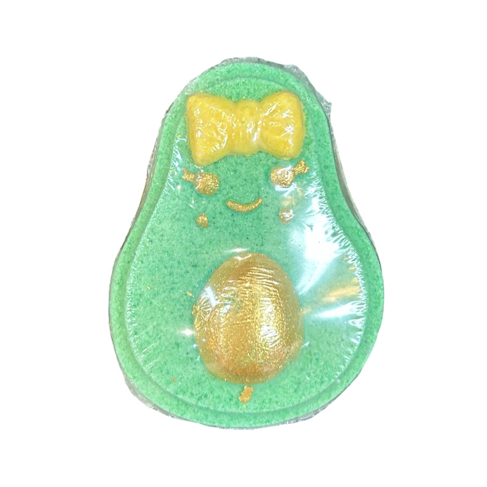 An avocado-shaped green bath bomb with a gold glittery seed and a yellow glittery bow-tie detail, shown on a plain white background.