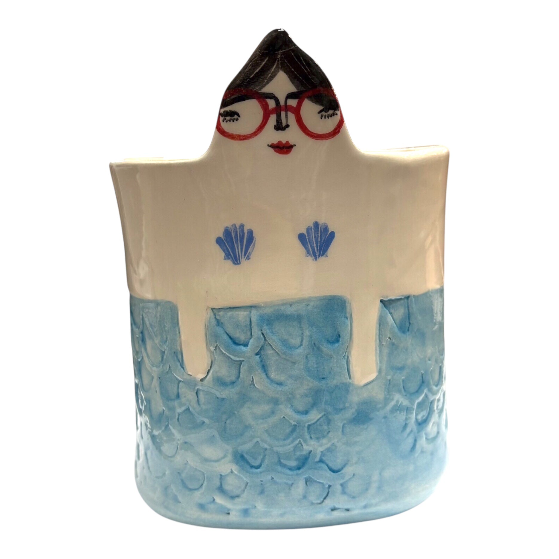 A handmade ceramic pot with teal mermaid scales and a lady's head with dark hair and red glasses.