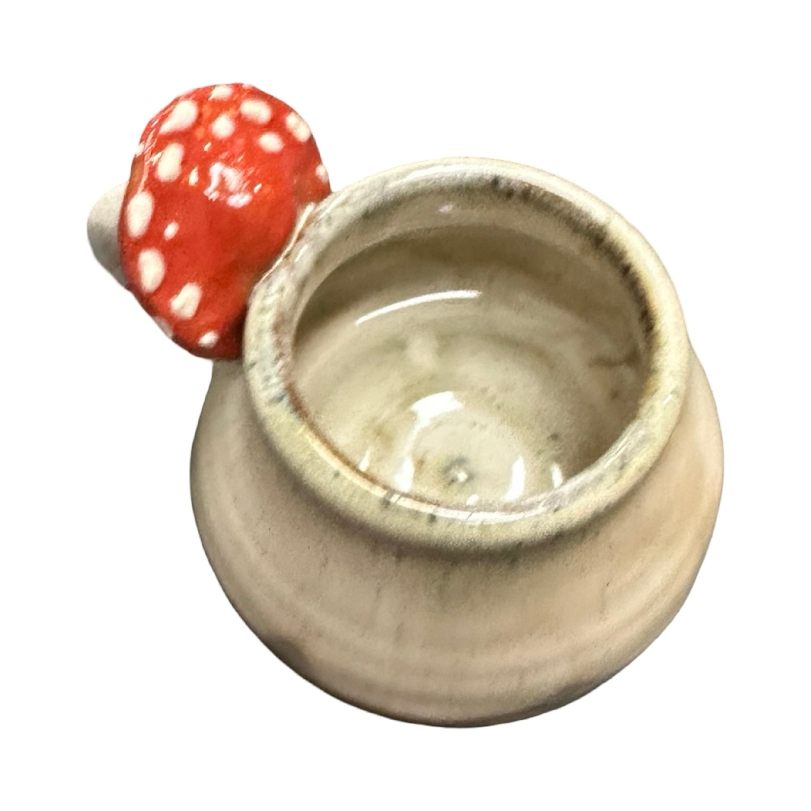 Ceramic mug with a red mushroom-shaped handle on a white background.