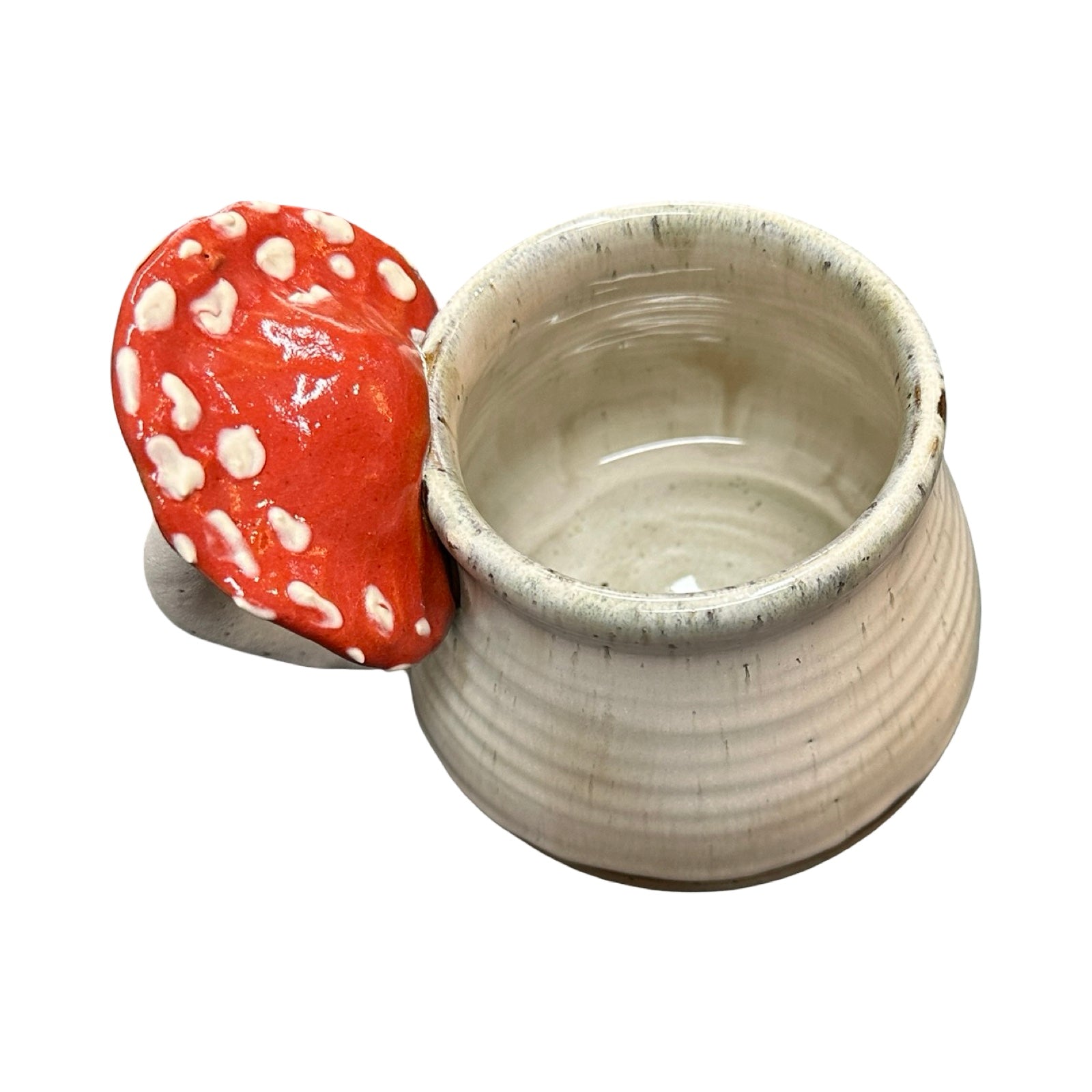 Ceramic mug with a red mushroom-shaped handle on a white background.