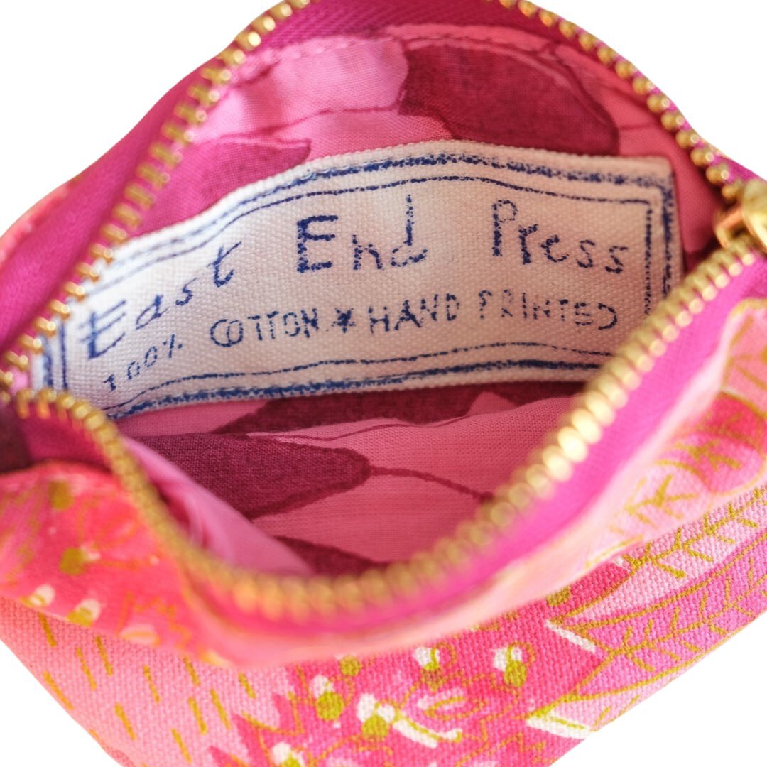 The inside of a pink bird coin purse with pink lining.