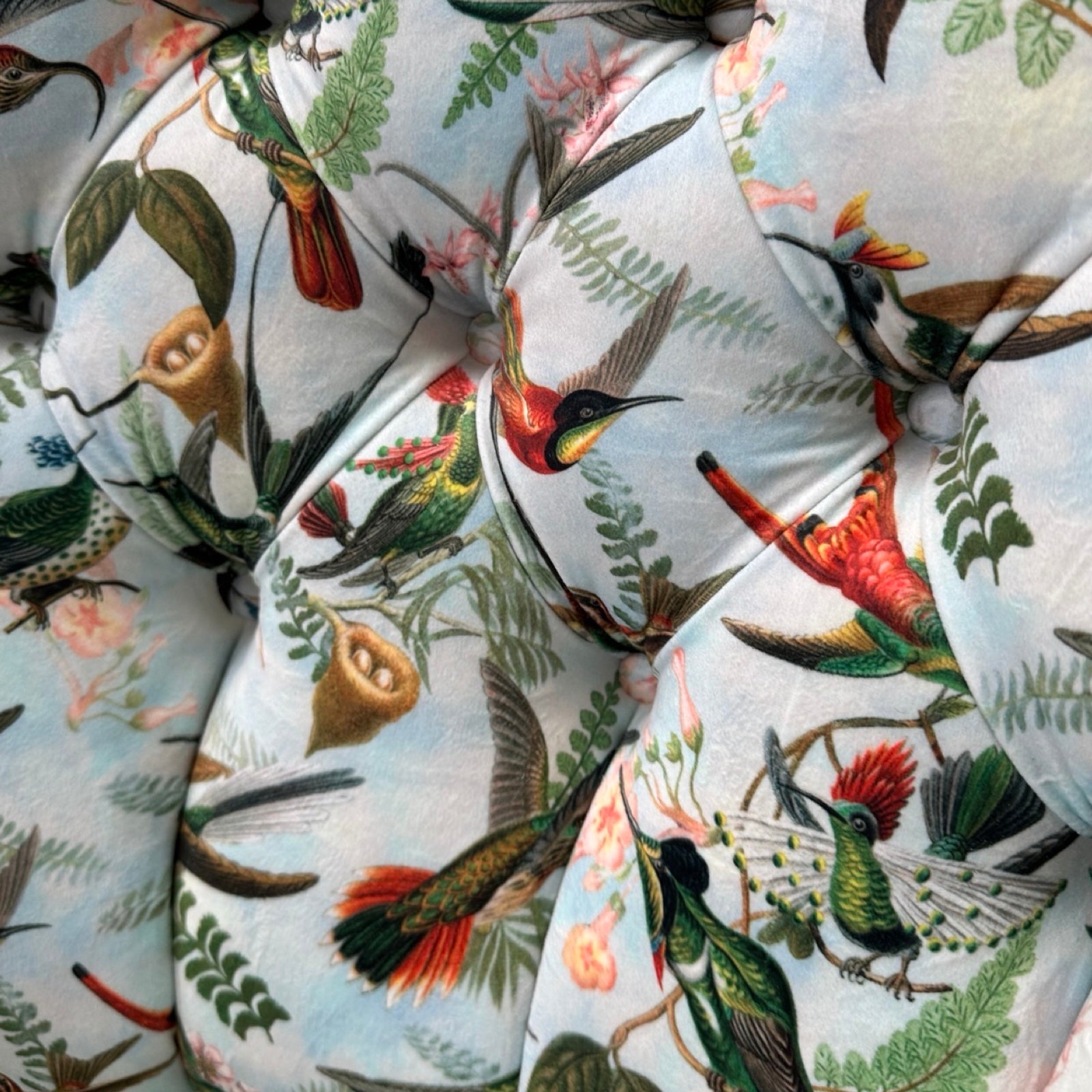 Close-up of fabric with colorful bird and floral pattern.