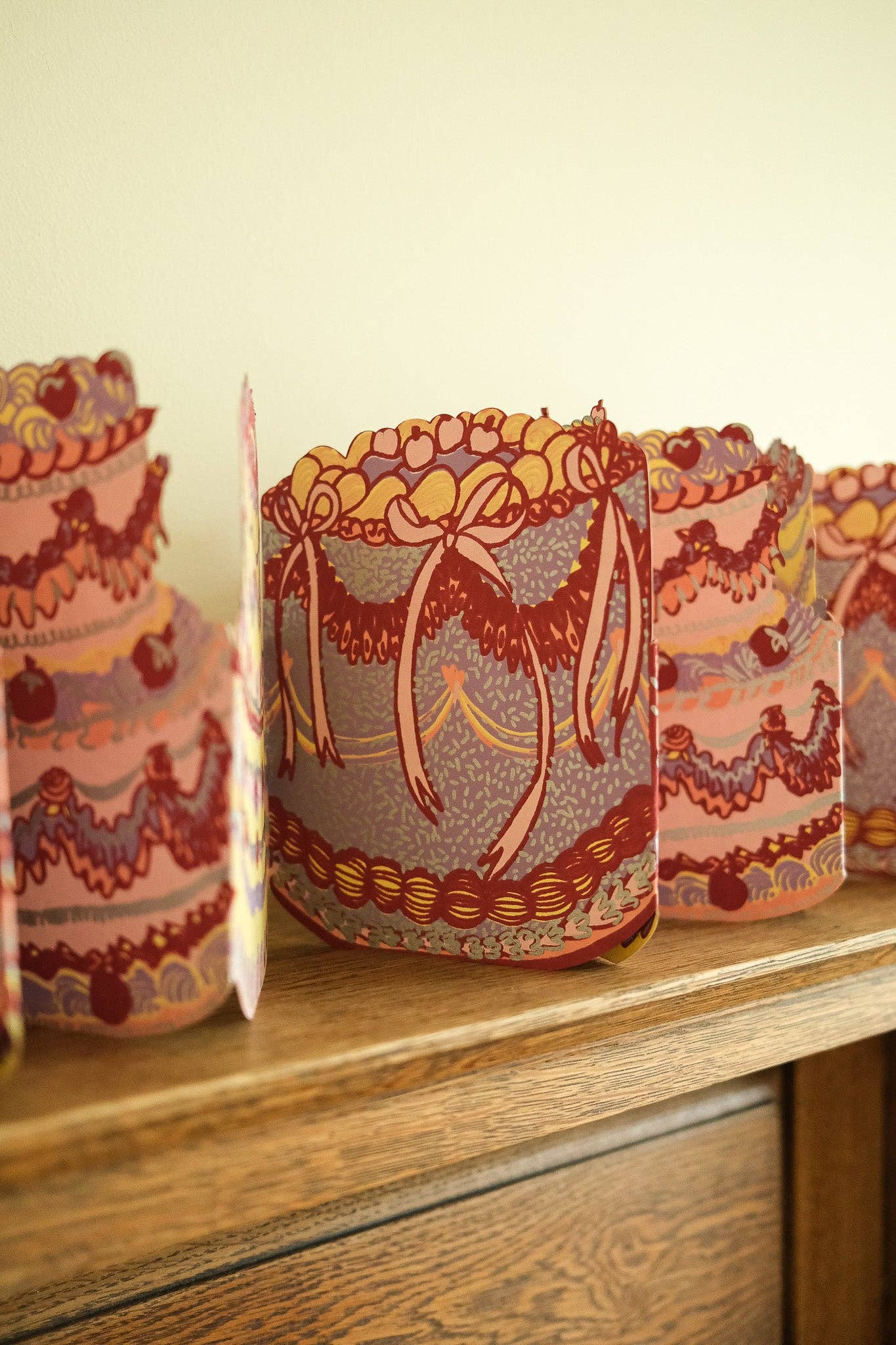 Decorative paper cakes with intricate patterns on a wooden surface.
