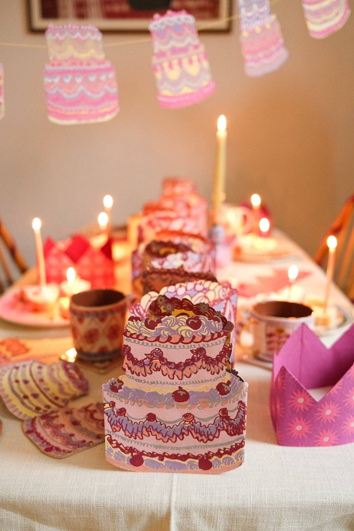 Decorative cake with candles on a table with a festive atmosphere.
