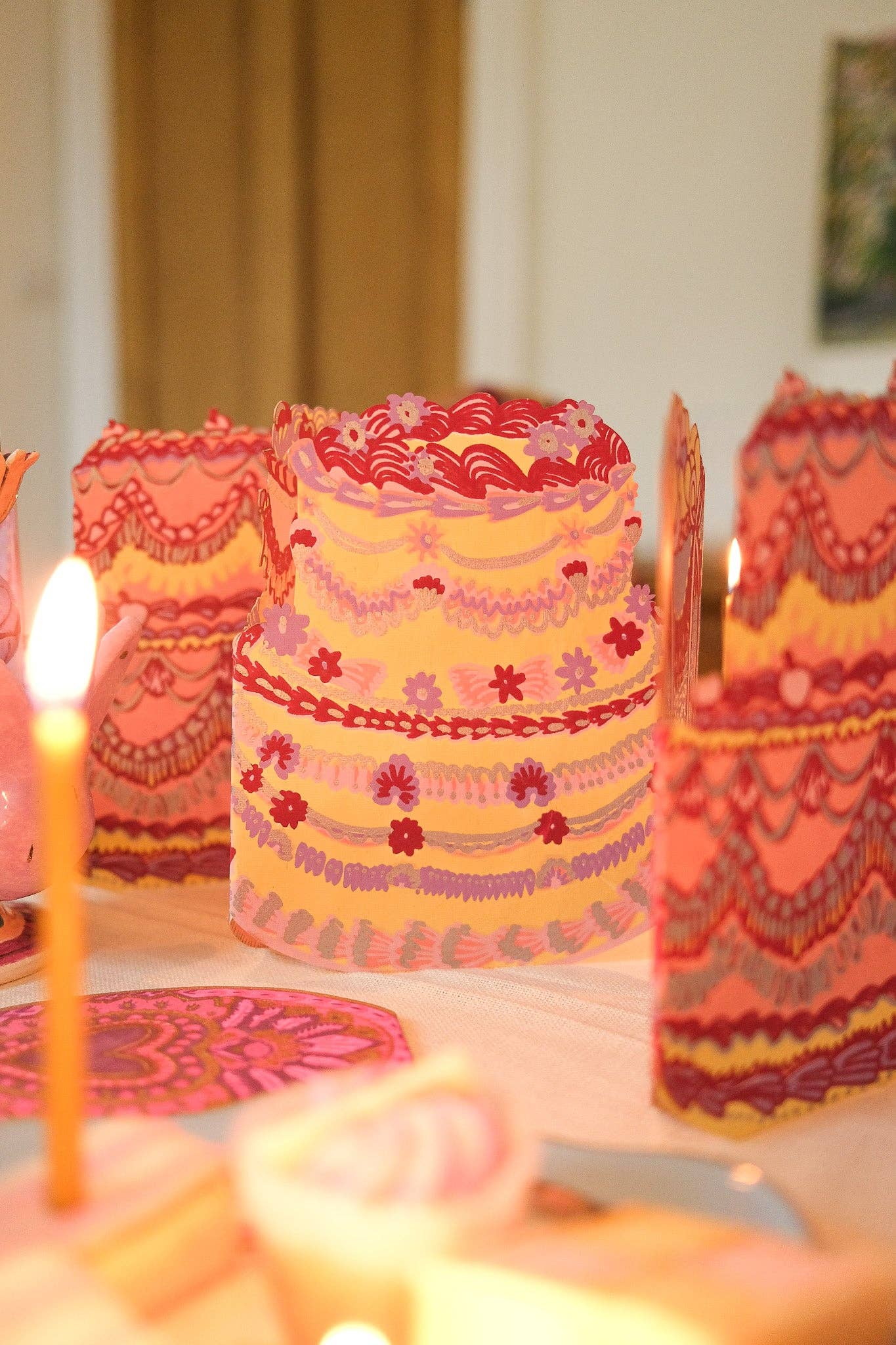 Decorative candles with intricate patterns and designs on a blurred background.