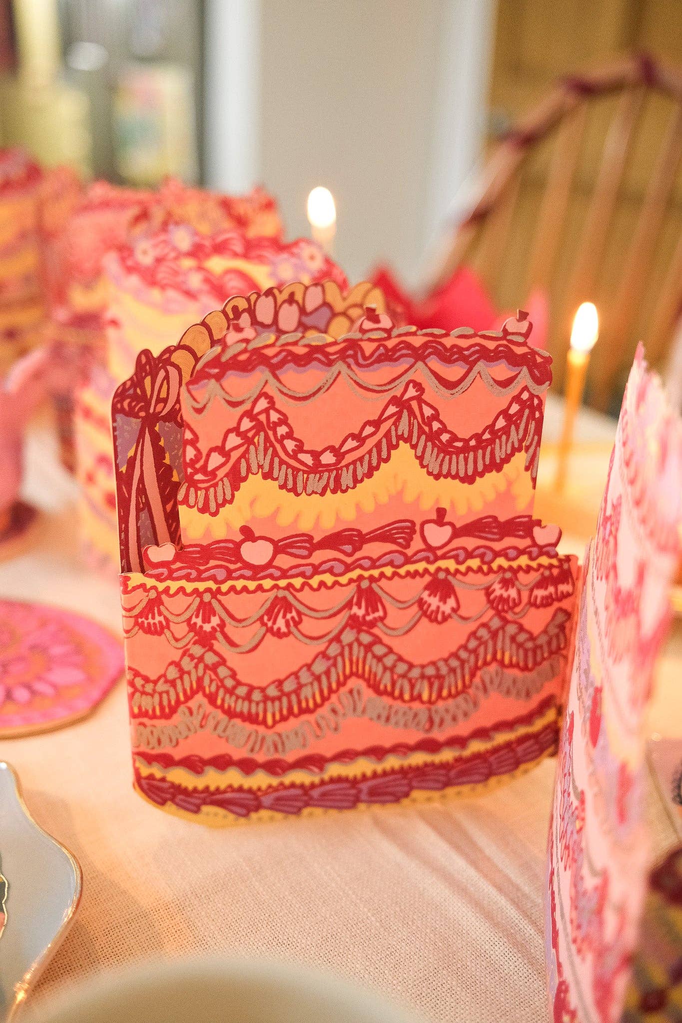 Decorative cake with intricate designs on a table with blurred background.