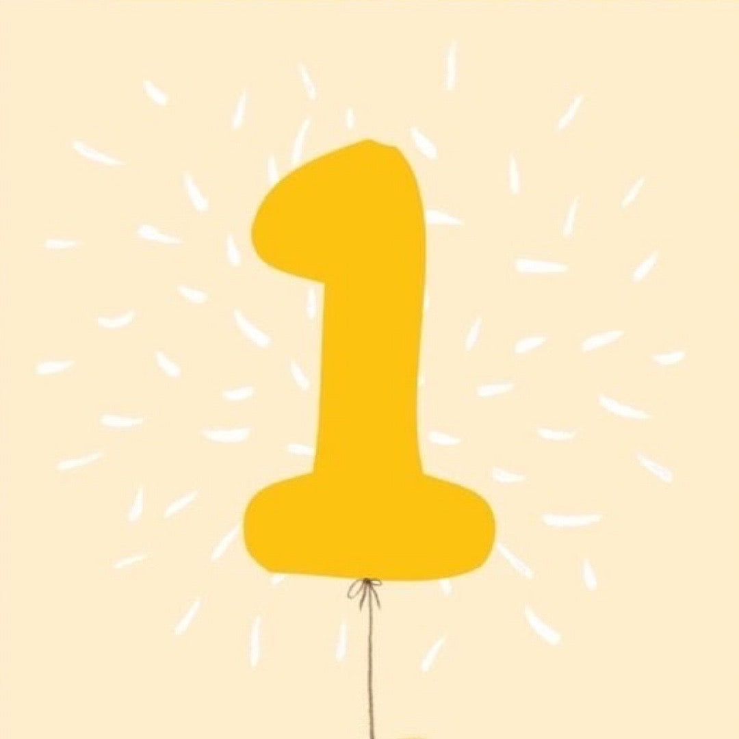 Yellow balloon shaped like the number '1' on a beige background with white dashes.