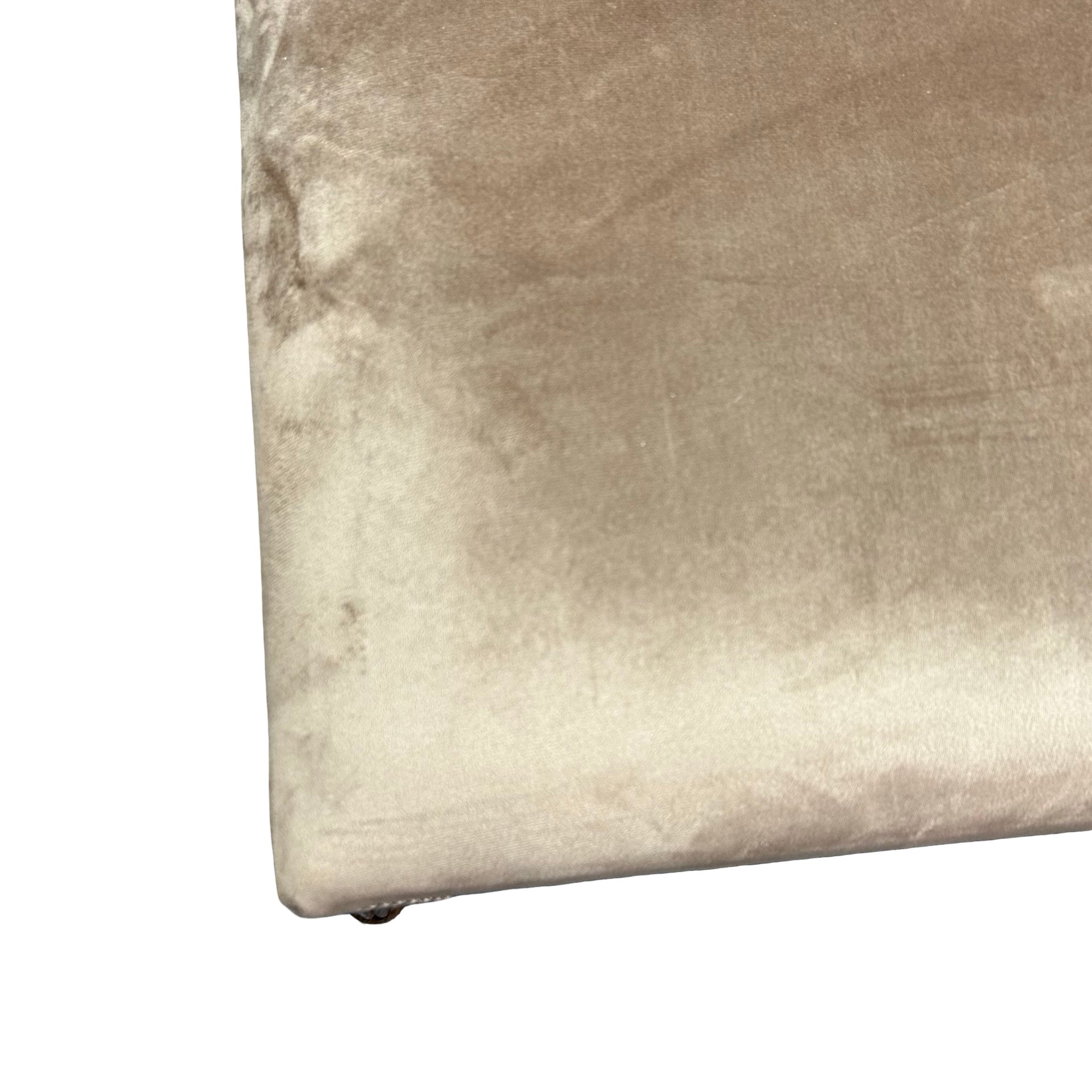Close-up of a textured beige bench on a white background.