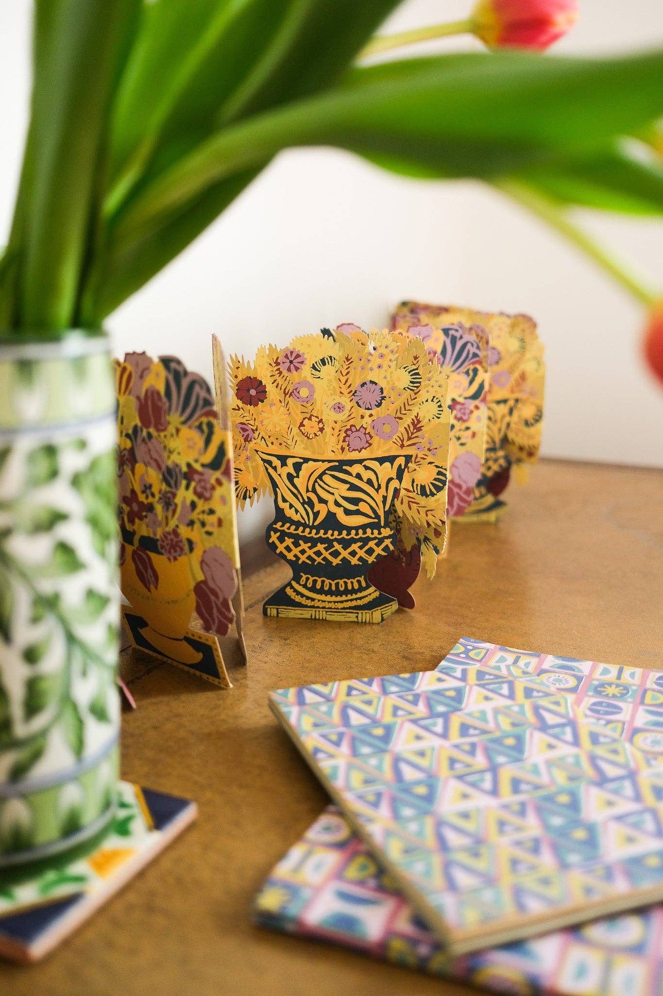 Colourful patterned notebooks on a wooden surface with a blurred background.