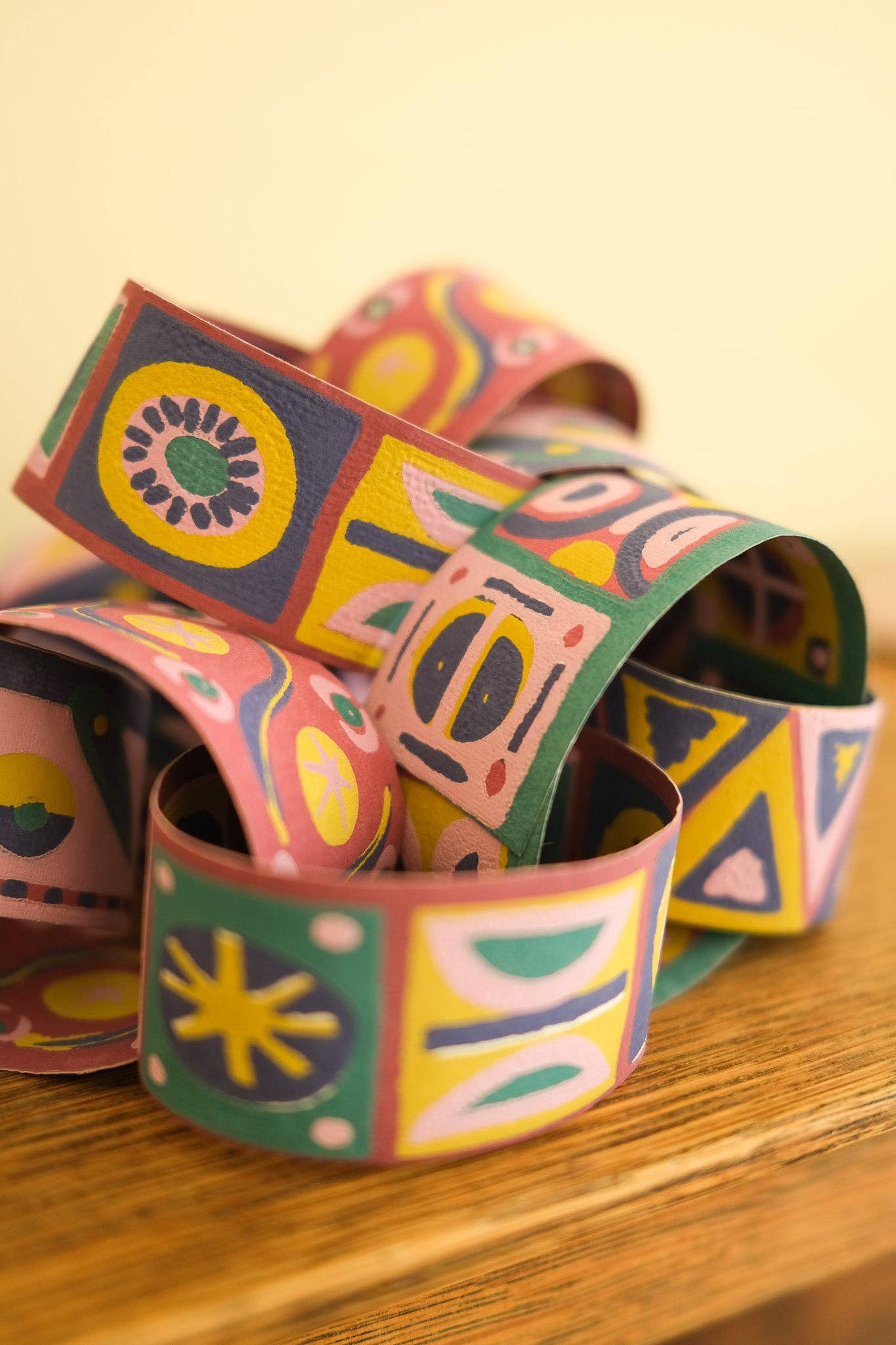 Colourful patterned paper chains on a wooden surface.