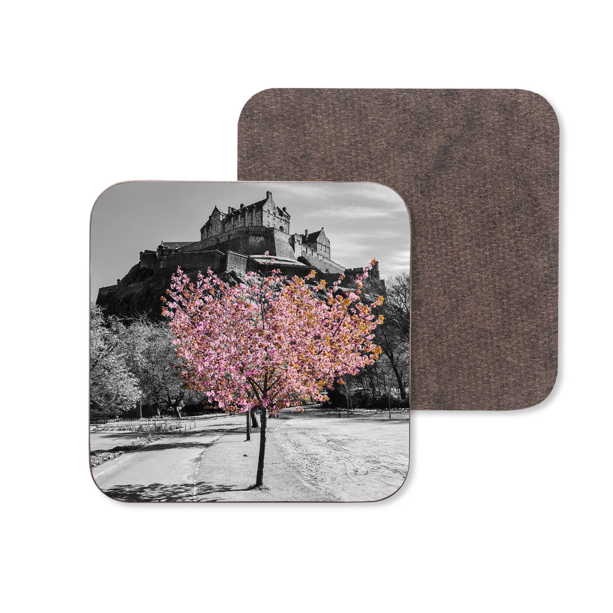 A black and white image of Edinburgh castle with a pink tree with blossom underneath on a coaster.