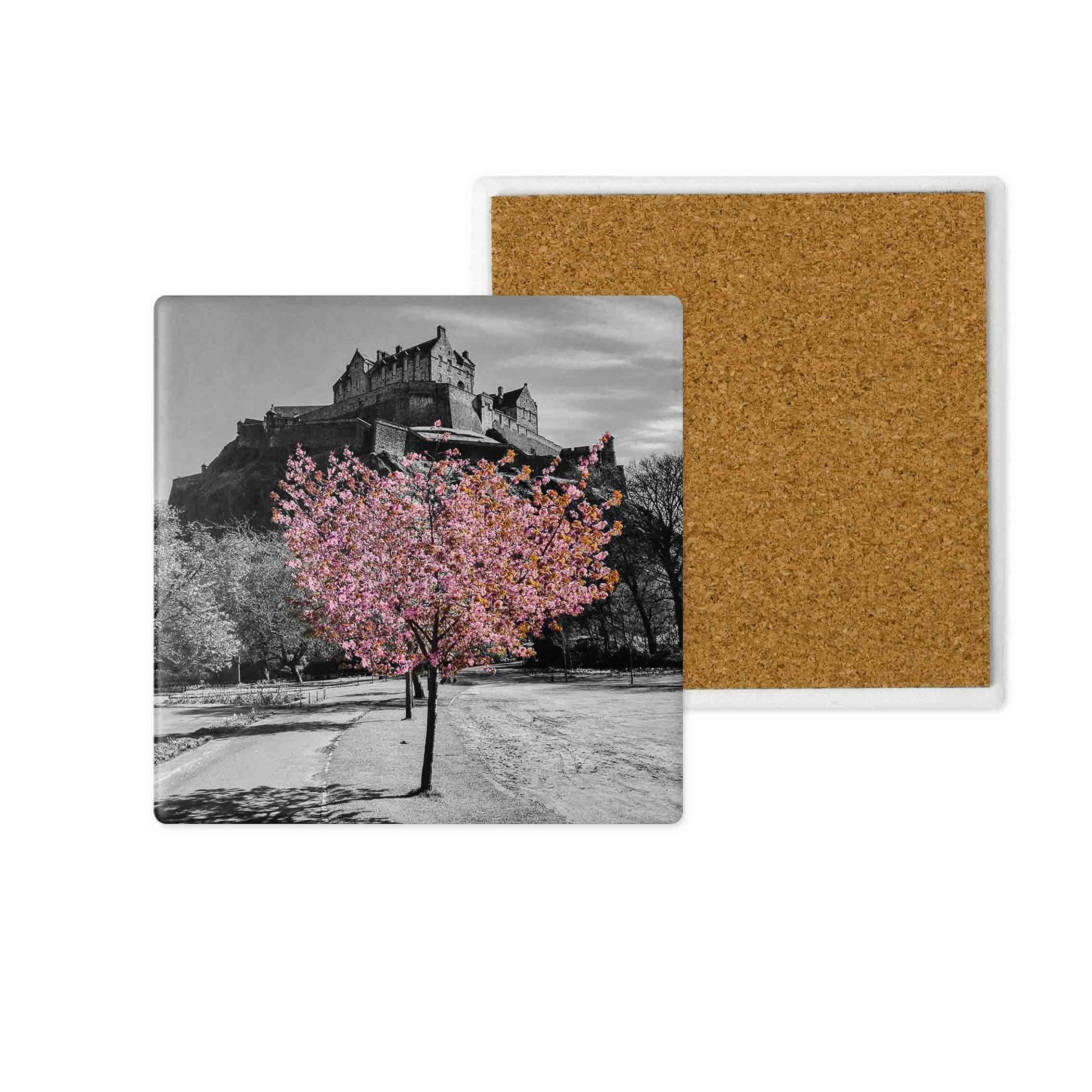A black and white image of Edinburgh Castle and a pink tree with blossom on a ceramic coaster.