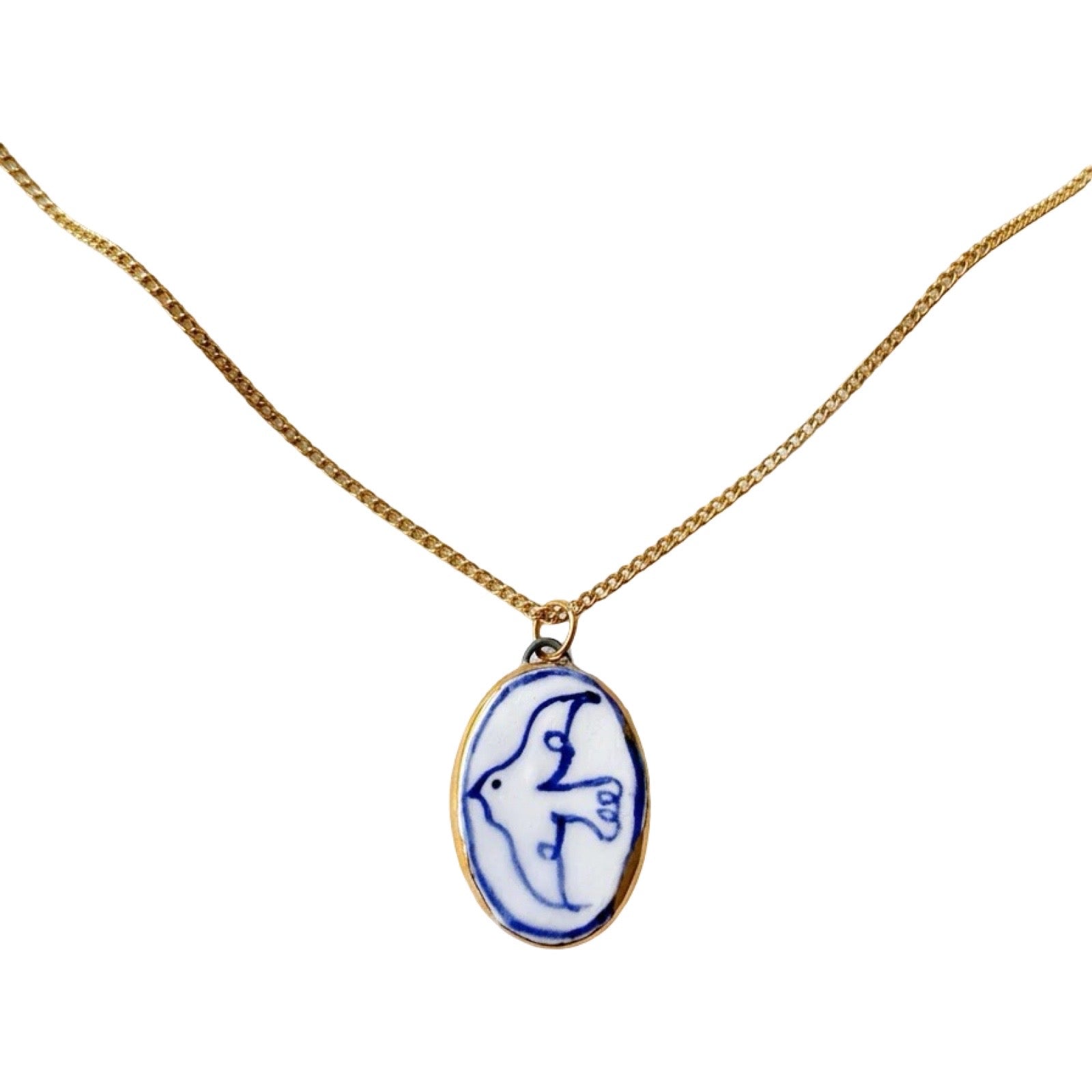 Necklace with a blue and white pendant on a gold chain against a white background.
