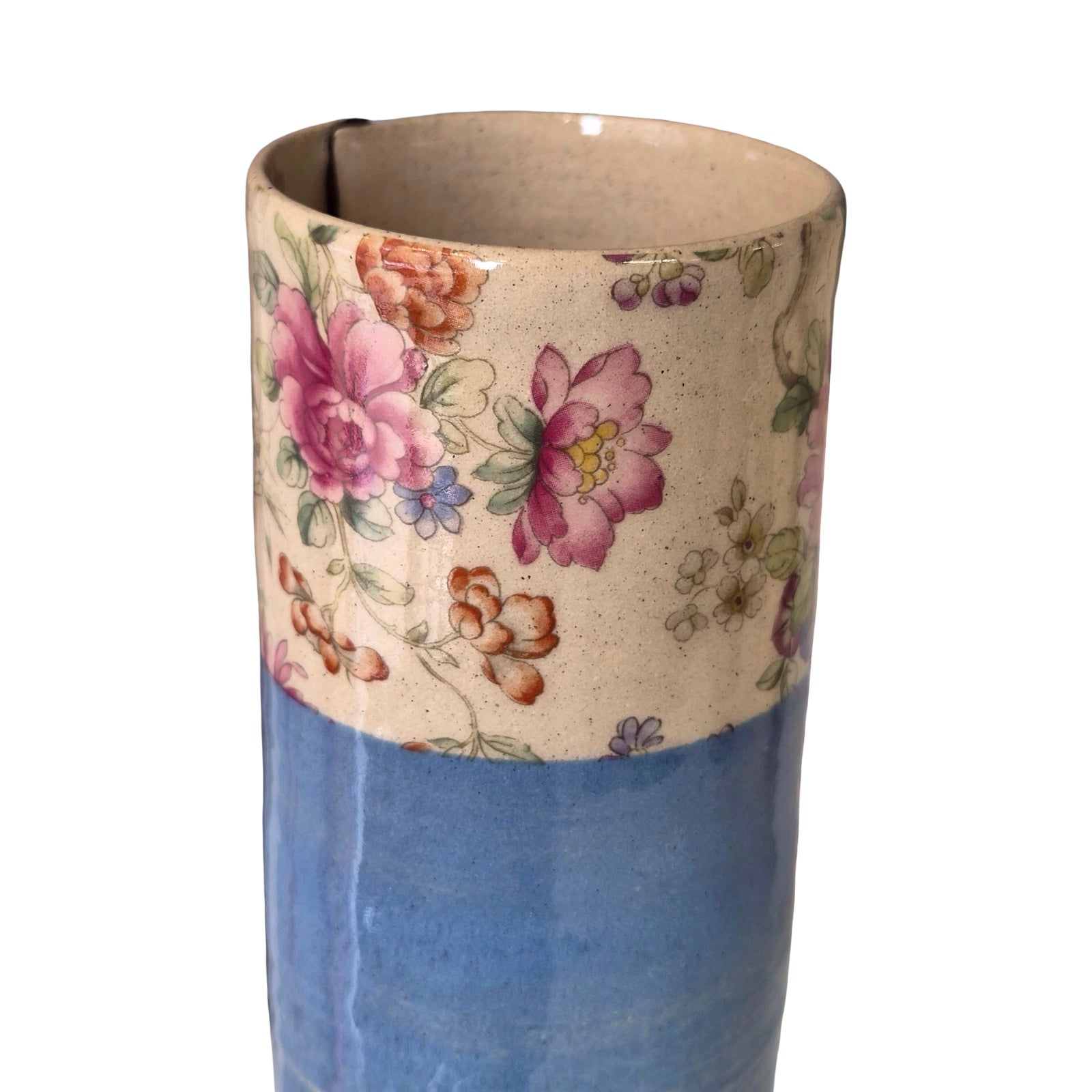 Ceramic vase with floral design on top and blue base on a white background.