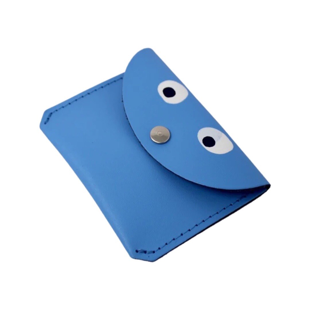 A blue leather coin purse with googly eyes and a gold fastening in the centre.