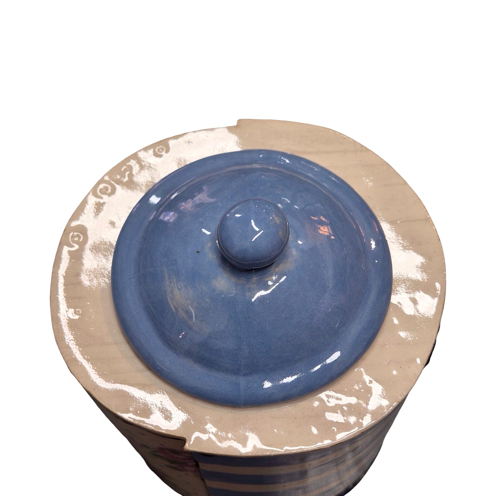 Ceramic jar with blue lid on a white background.