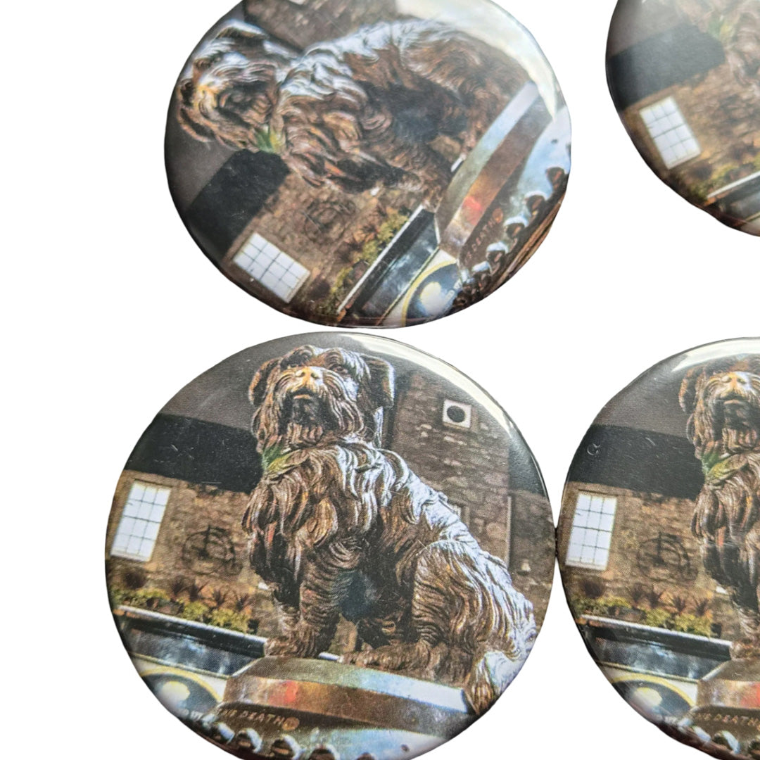 Set of four circular magnets with a dog statue design on a white background