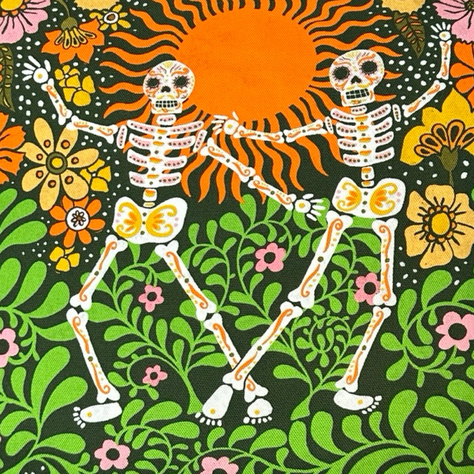 Decorative cushion with skeletons and floral design.