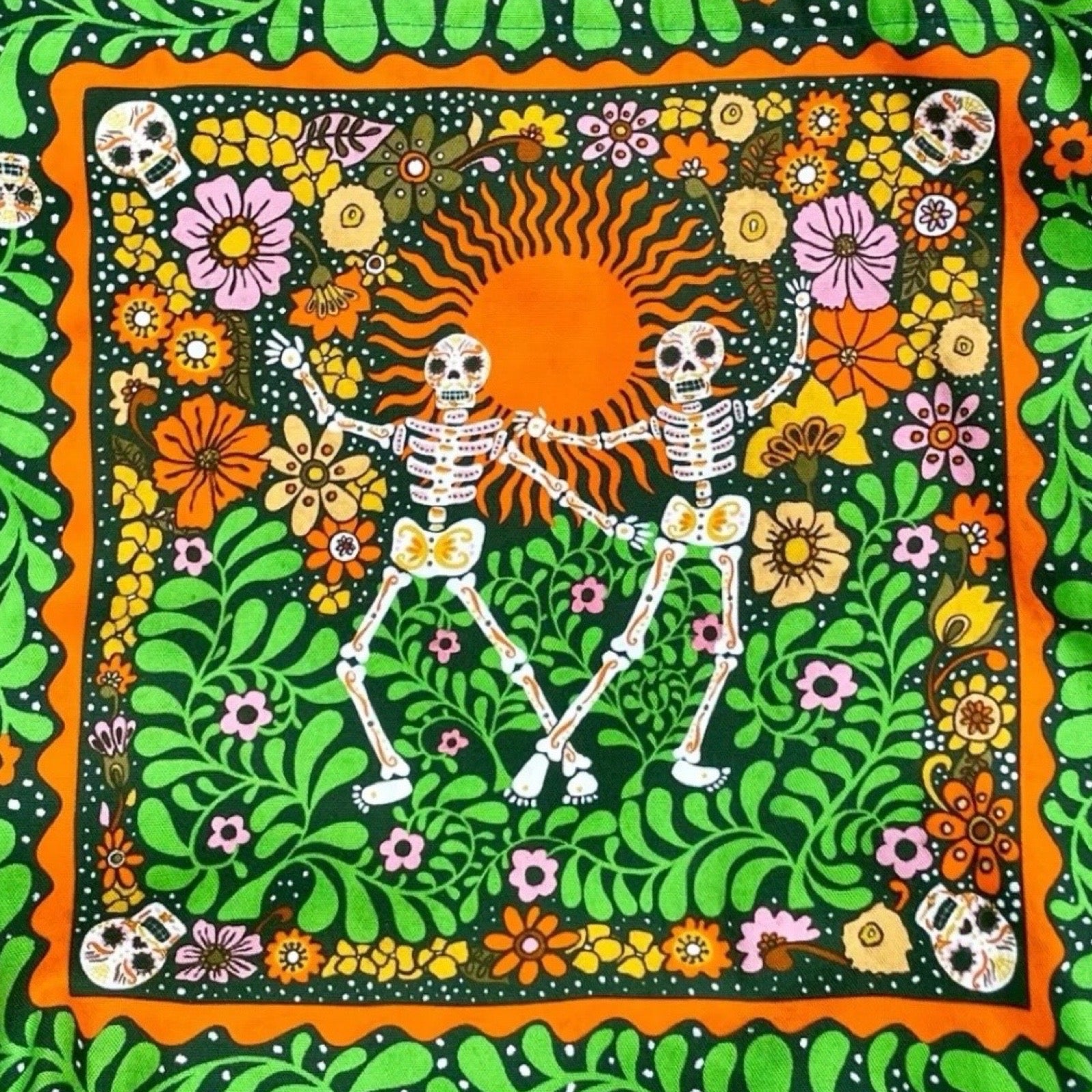 Fabulous tote bag featuring two skeletons dancing in a garden among bright flowers and green ferns.