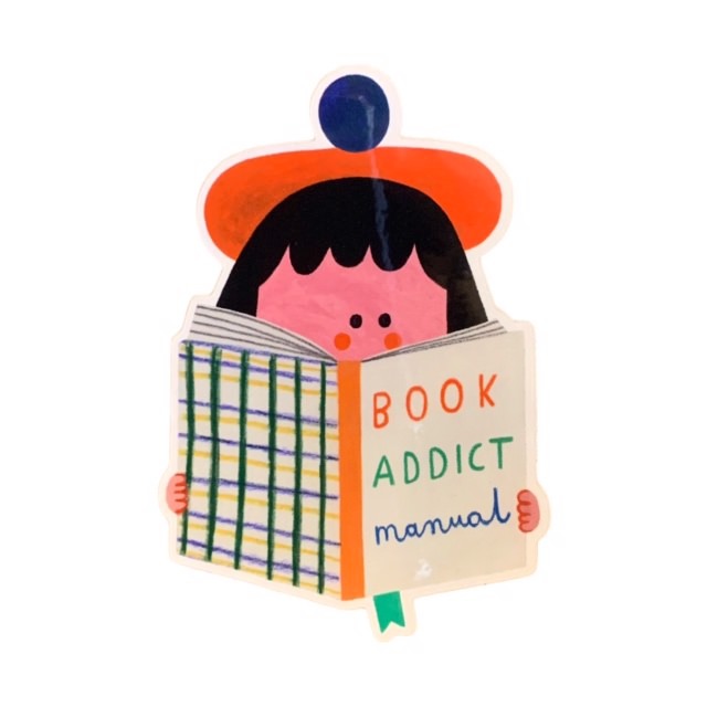 Vinyl sticker with a girl in a red beret with her face in a book called 'Book Addict Manual'.