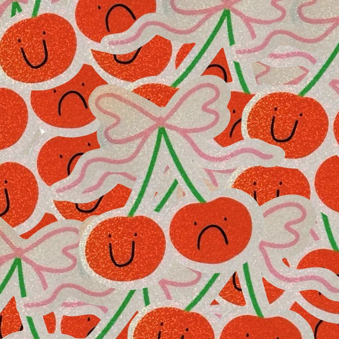 Pile of stickers of smiling and sad cherries with pink bows.