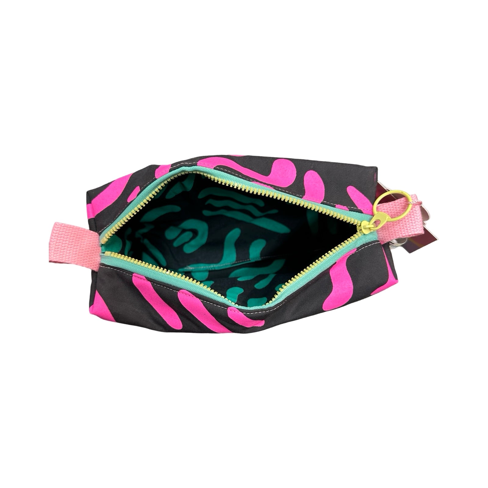A grey boxy cosmetic bag with a pink abstract design open showing a grey and turquoise abstract waterproof lining.