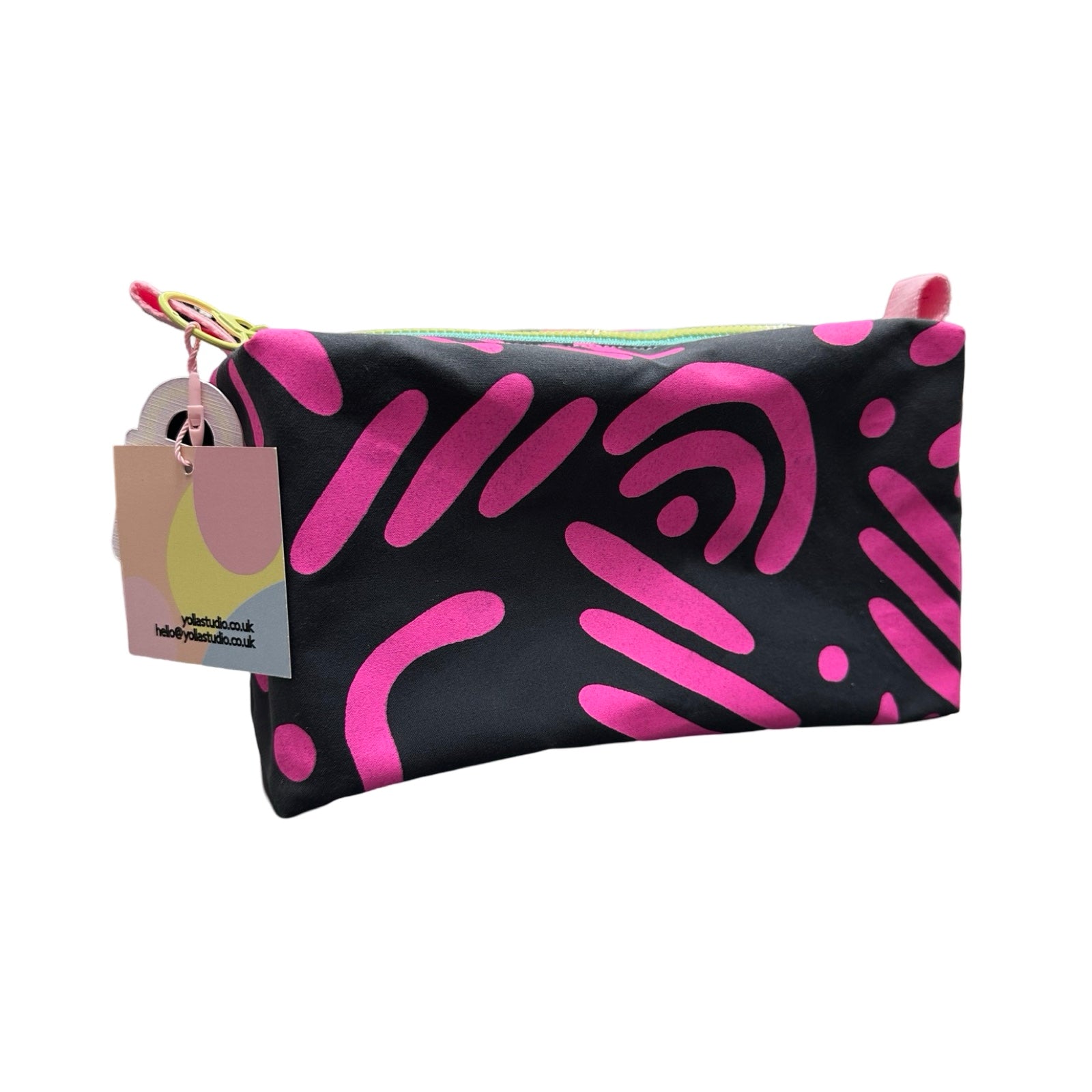 A grey boxy cosmetic bag with a pink abstract design.