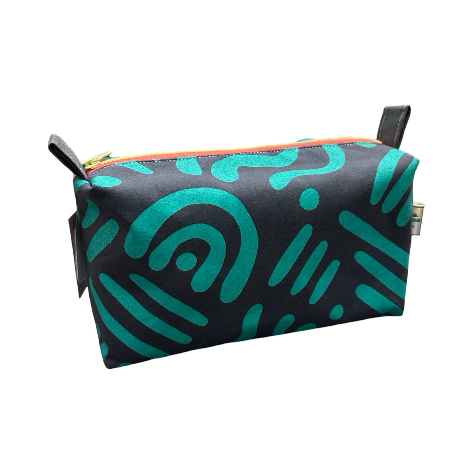 A grey boxy cosmetic bag with a turquoise abstract design.
