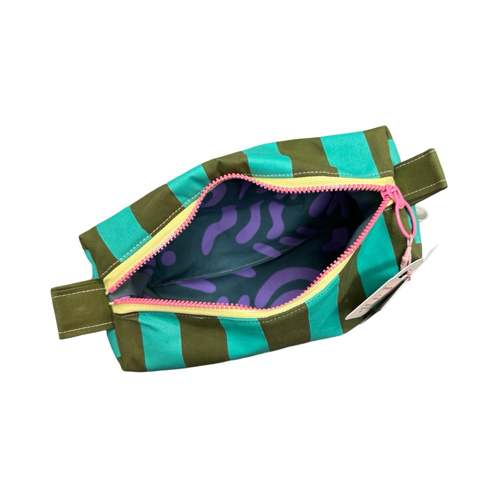 A boxy cosmetic bag in turquoise and grey stripes open showing grey and purple abstract lining fabric.