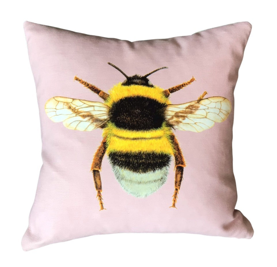 Blush velvet cushion with a bumblebee on the front.
