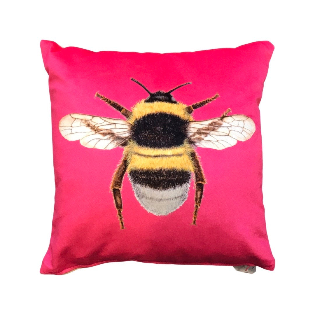 Pink velvet cushion with a bumblebee on the front.