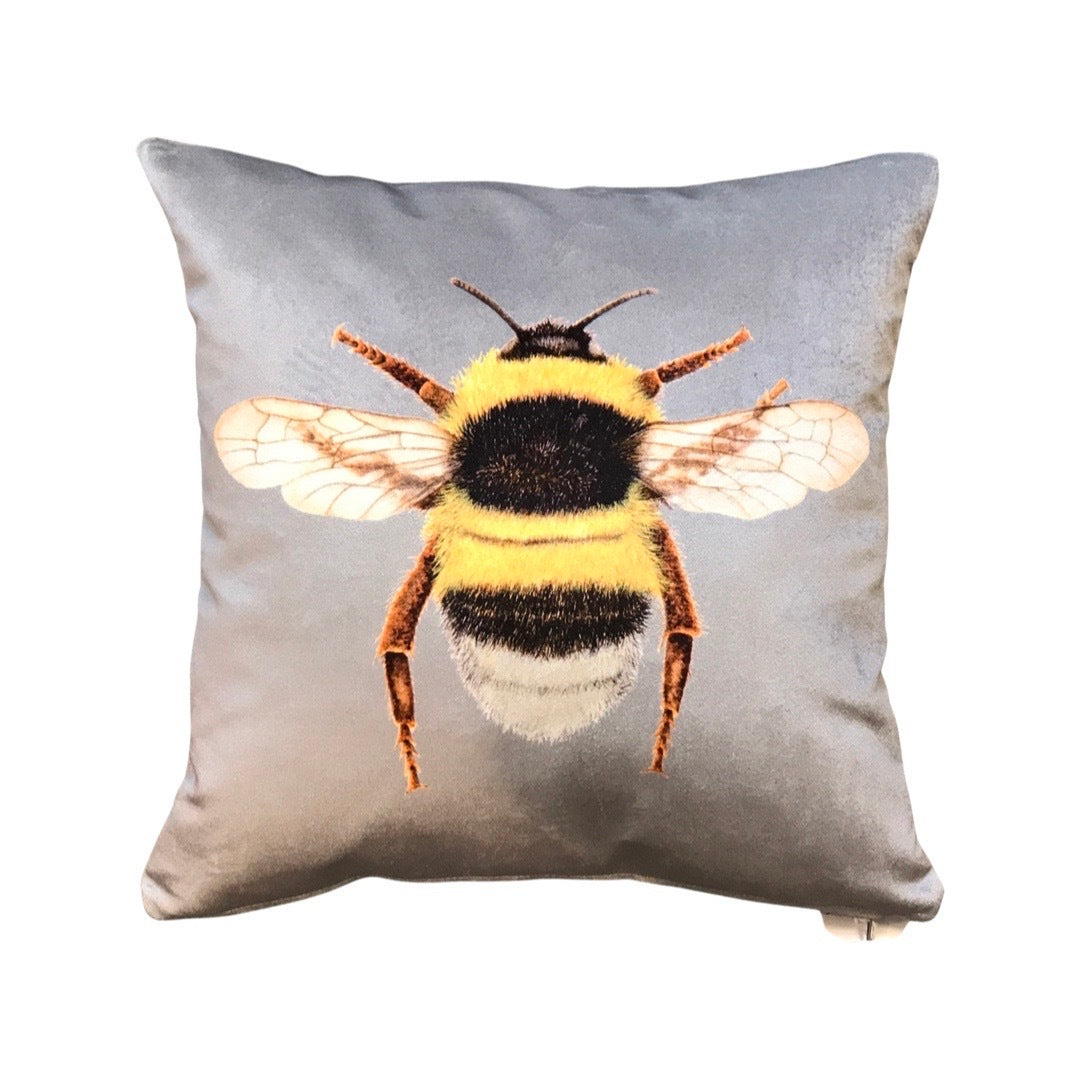 Silver velvet cushion with a bumblebee on the front.
