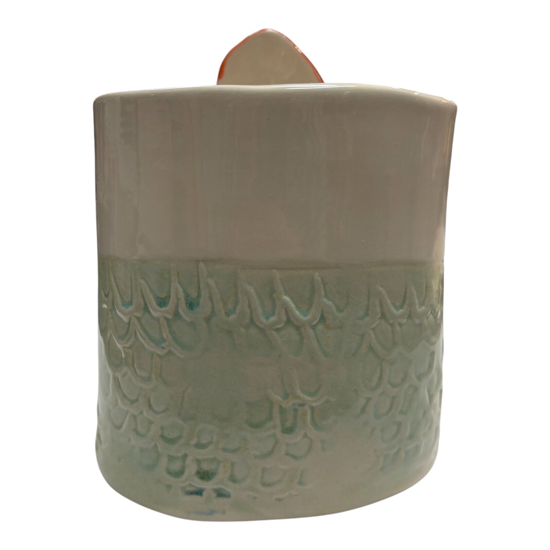 The back of a handmade ceramic pot with pale green mermaid scales.
