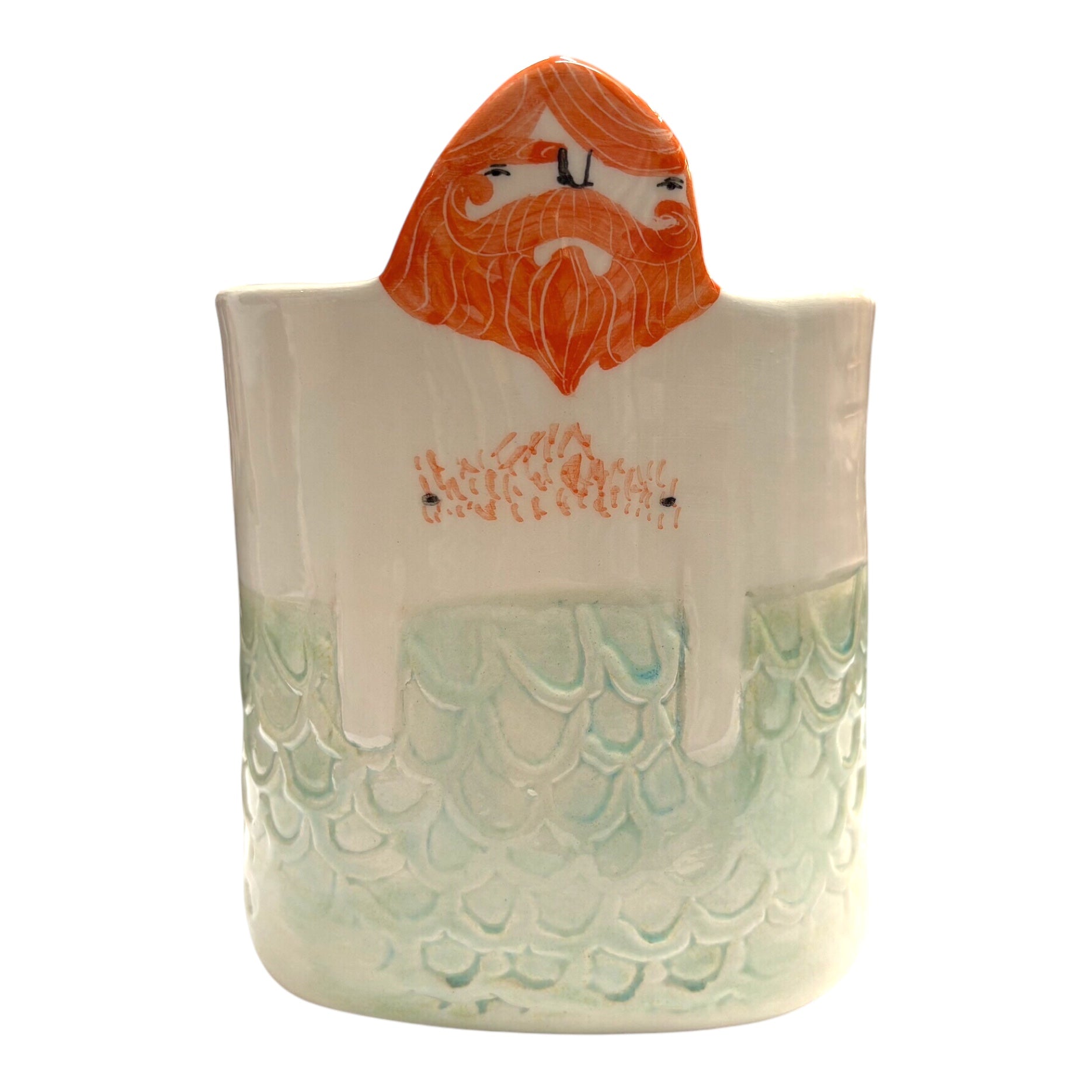 A handmade ceramic pot with pale green mermaid scales and a man's head with ginger hair and a beard.