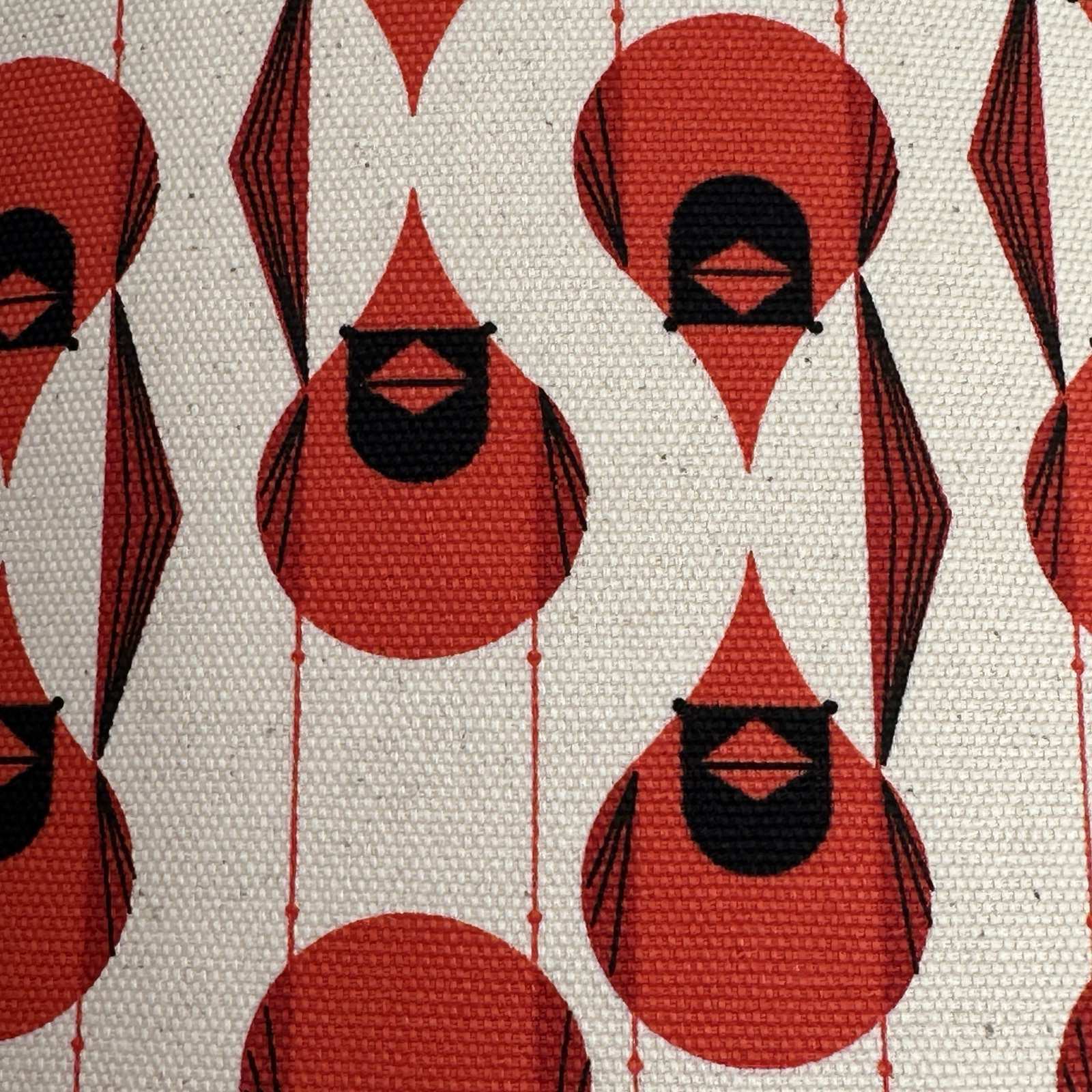 Pattern of red and black geometric shapes on a textured beige background.