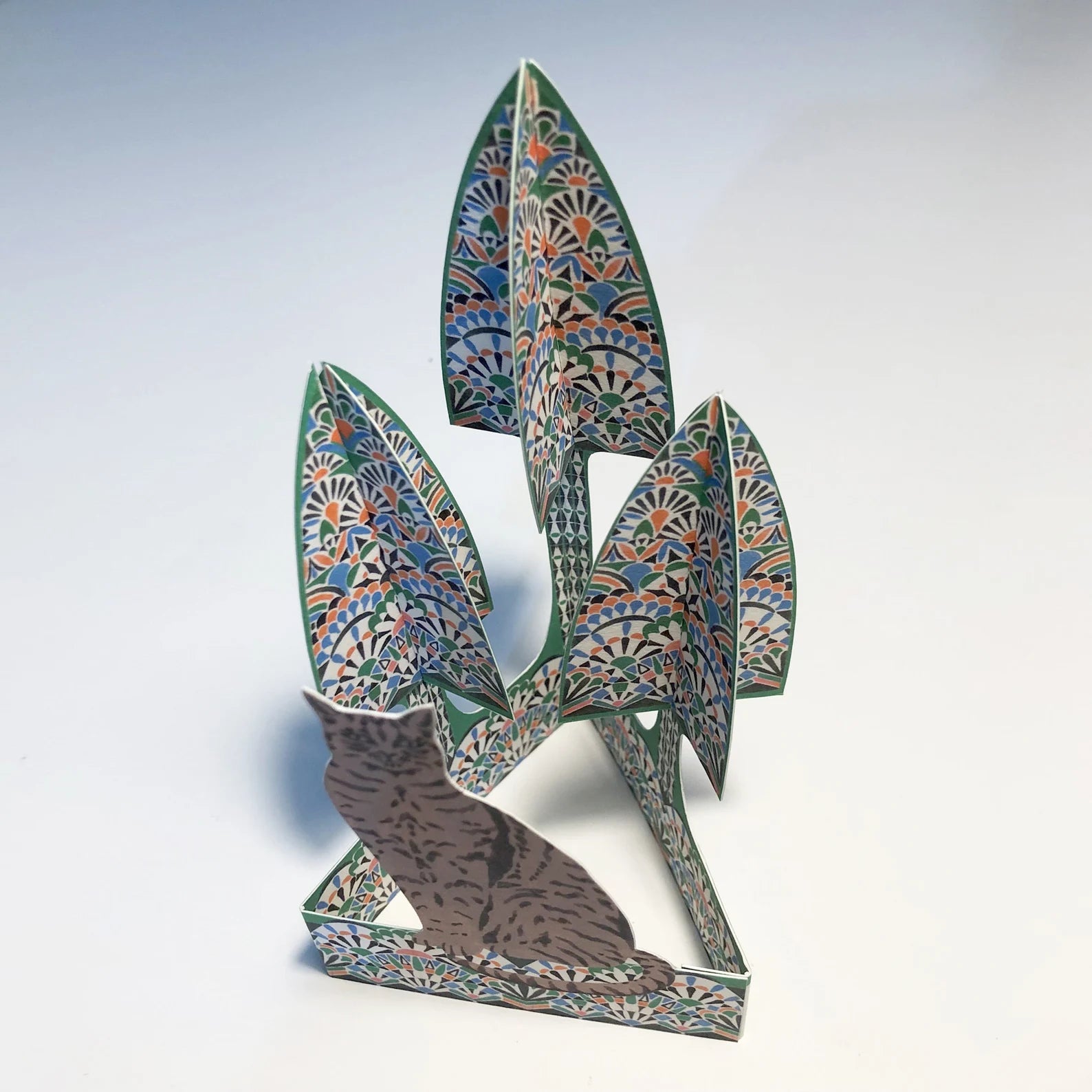 Decorative paper sculpture of a cat with floral patterns on a white background.