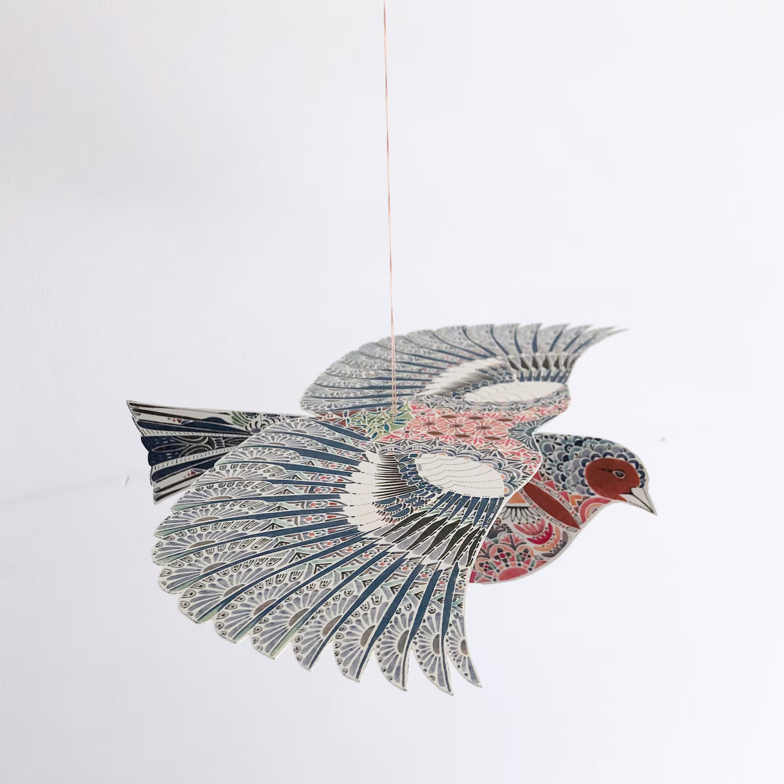 Decorative paper bird with intricate patterns on a white background.