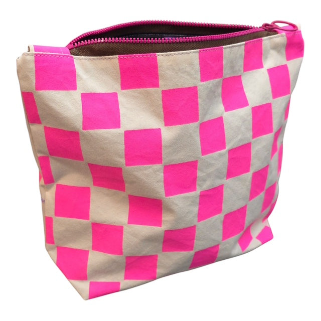 A screen-printed checked cosmetic bag in pink and white with a pink zip.