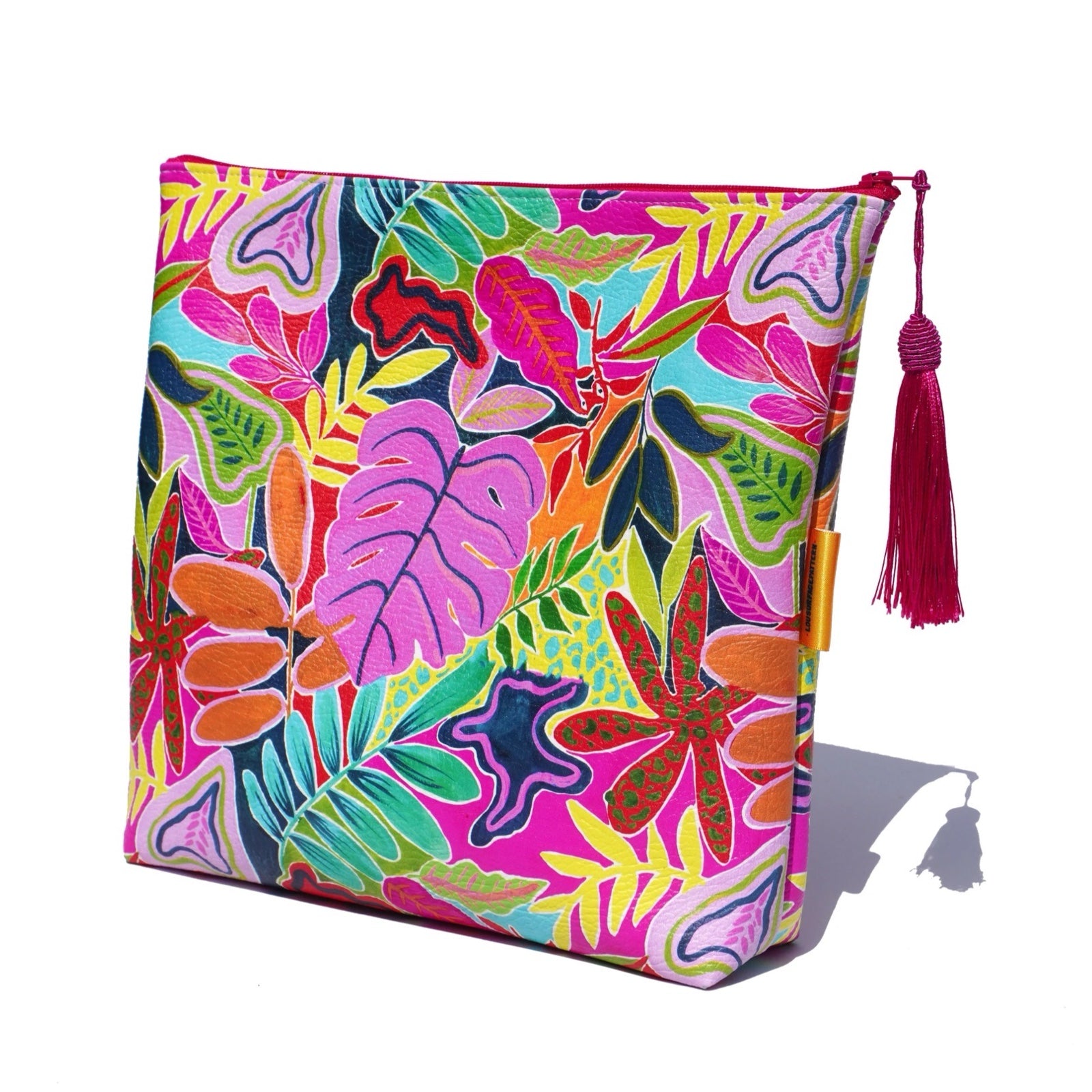 Vegan leather is printed in a bright and colourful tropical leaves design, and the bag is finished with a fabulous matching tassel on the end of the zip.