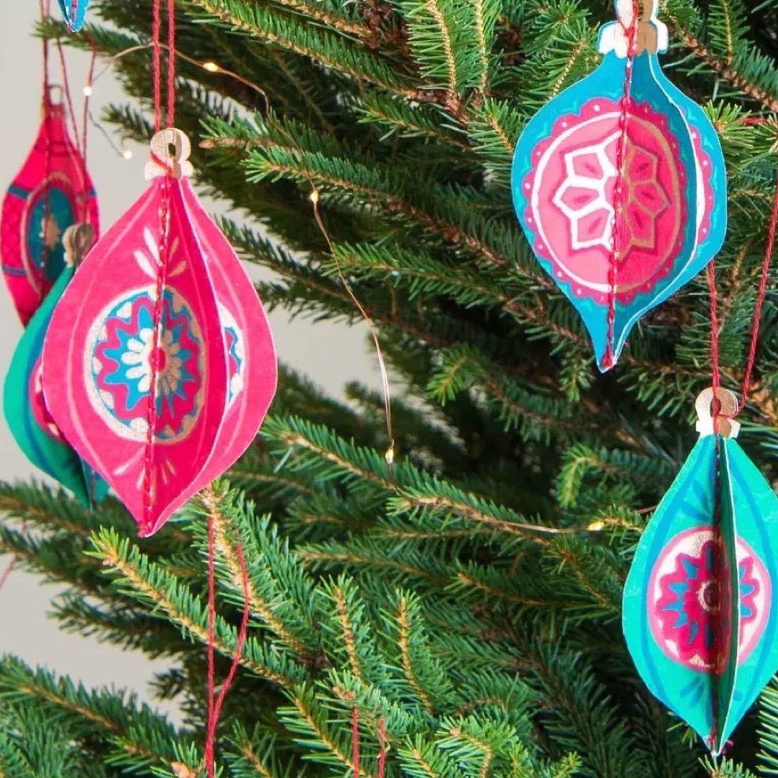 Colourful Christmas ornaments hanging on a tree.