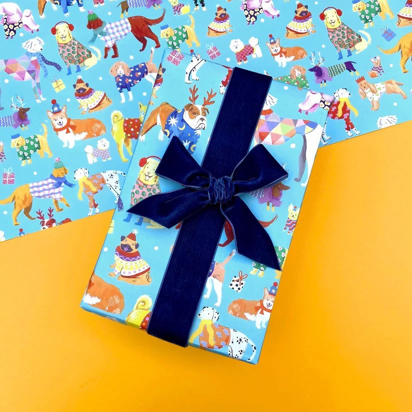 Present with blue Christmas dog wrapping paper on a yellow table.